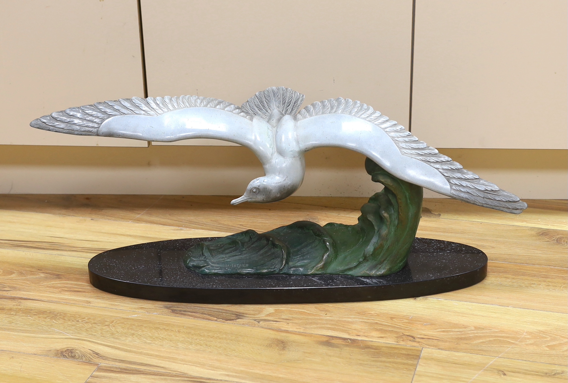 M. Leducq, a painted spelter model of a gull in flight on marble base, 86cm wingspan